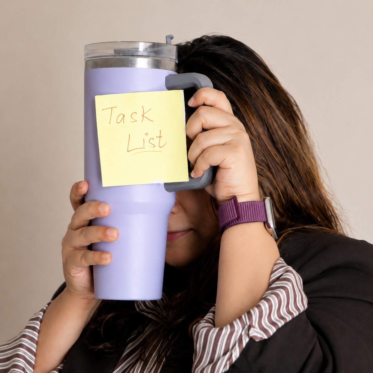 Mehak holding a tumbler with a "Task List" sticky note