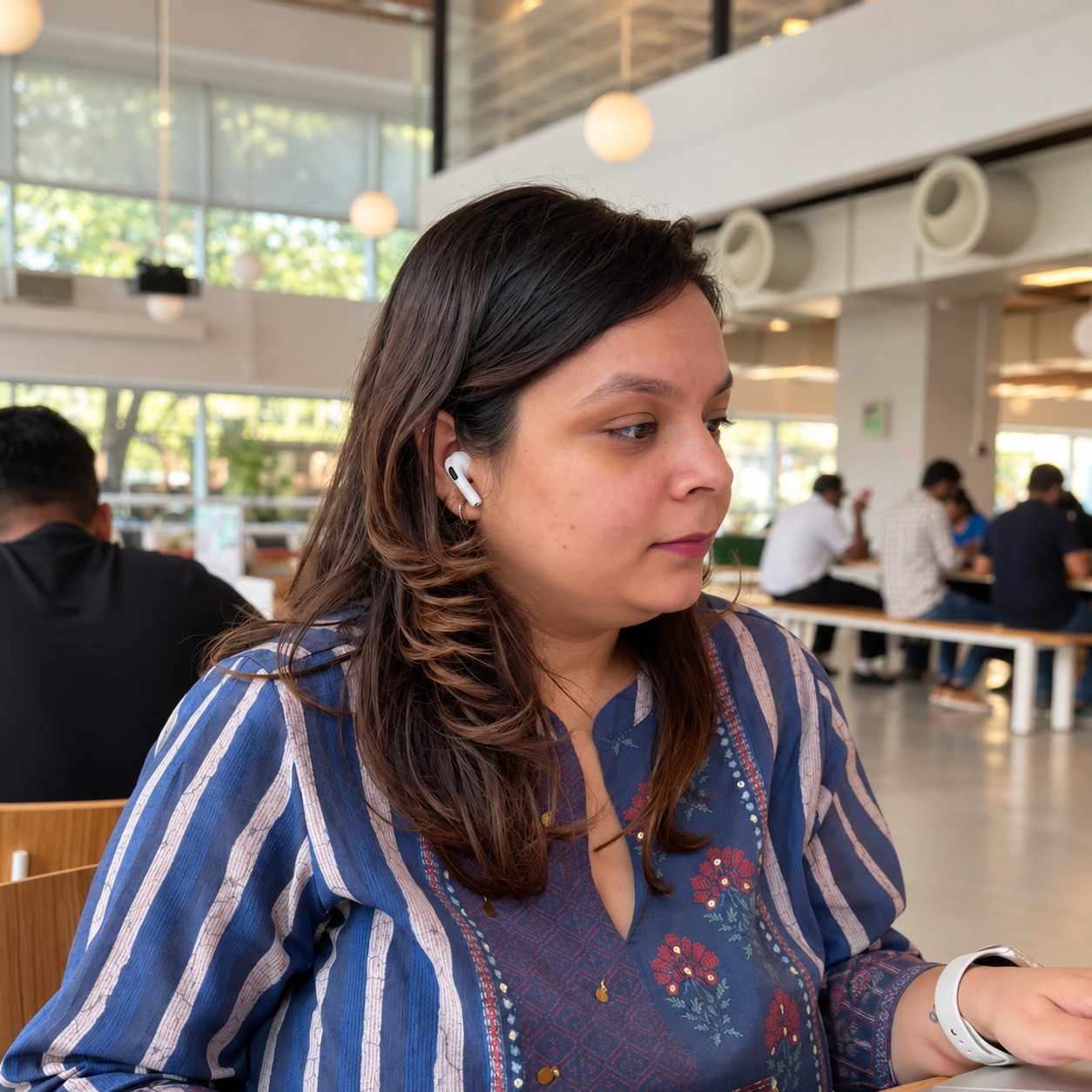 Mehak working at a shared workspace, focused